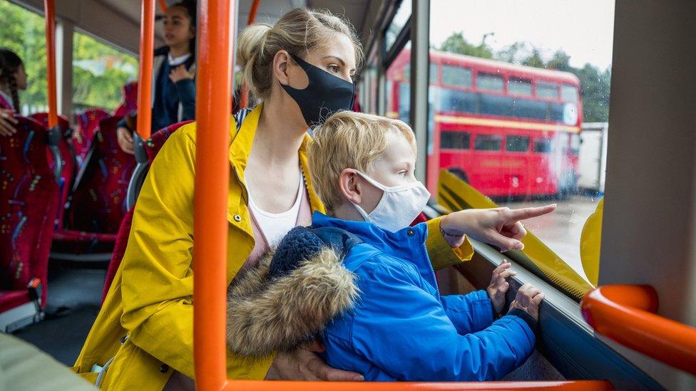 Mother and son on the bus wearing face masks