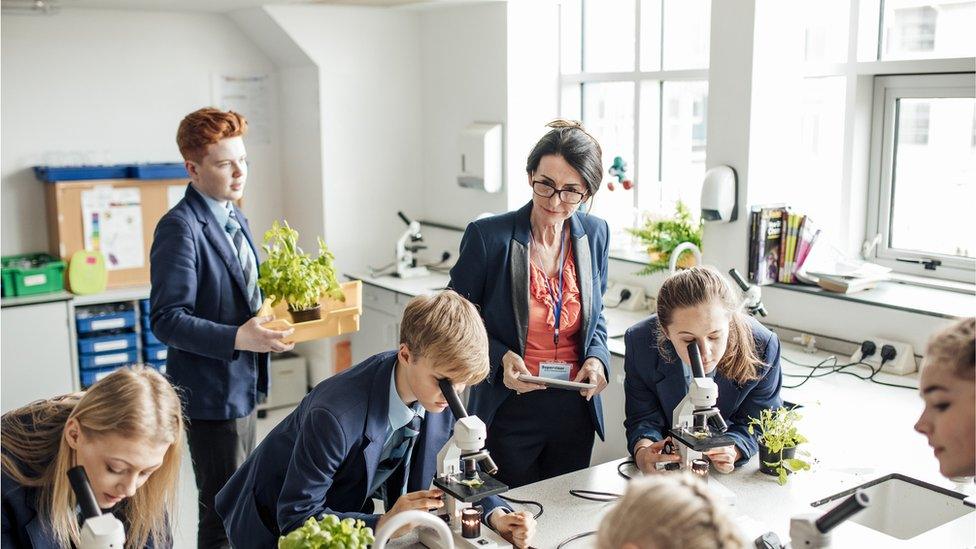 Overview of teacher looking over students while they work.