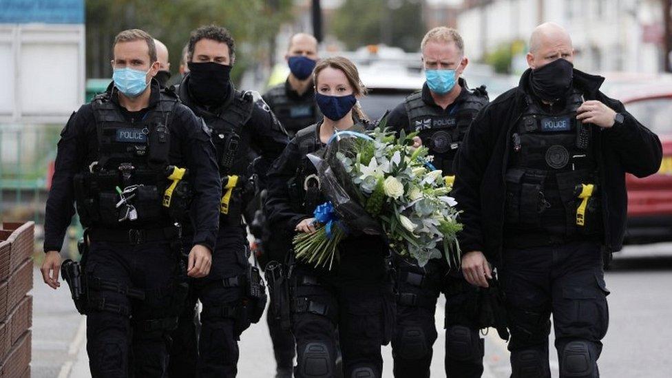 Police officers arrive to pay respects outside the custody centre where a British police officer has been shot dead in Croydon, south London