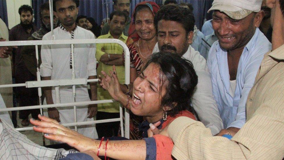 Family members cry near the body of their relative who was killed after consuming illegal alcohol, in Hyderabad, Pakistan, 22 March 2016