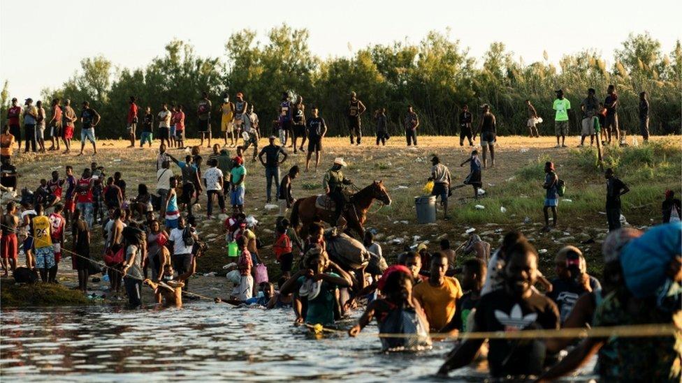 Border Patrol agents on horseback push Haitians back from the US border