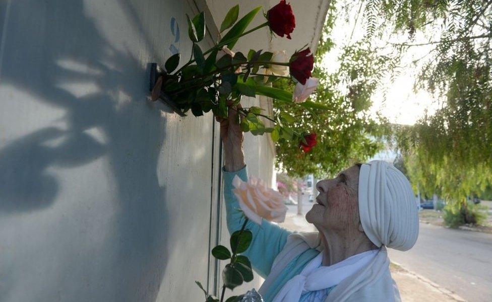 French woman living in Morocco lays flowers on the door of the house where French actor Michel Galabru was born on October 27, 1922 in the Moroccan coastal city of Safi, some 250 kilometres (155 miles) southwest of Casablanca, on January 5, 2016. Galabru died on January 4, 2016 aged 93