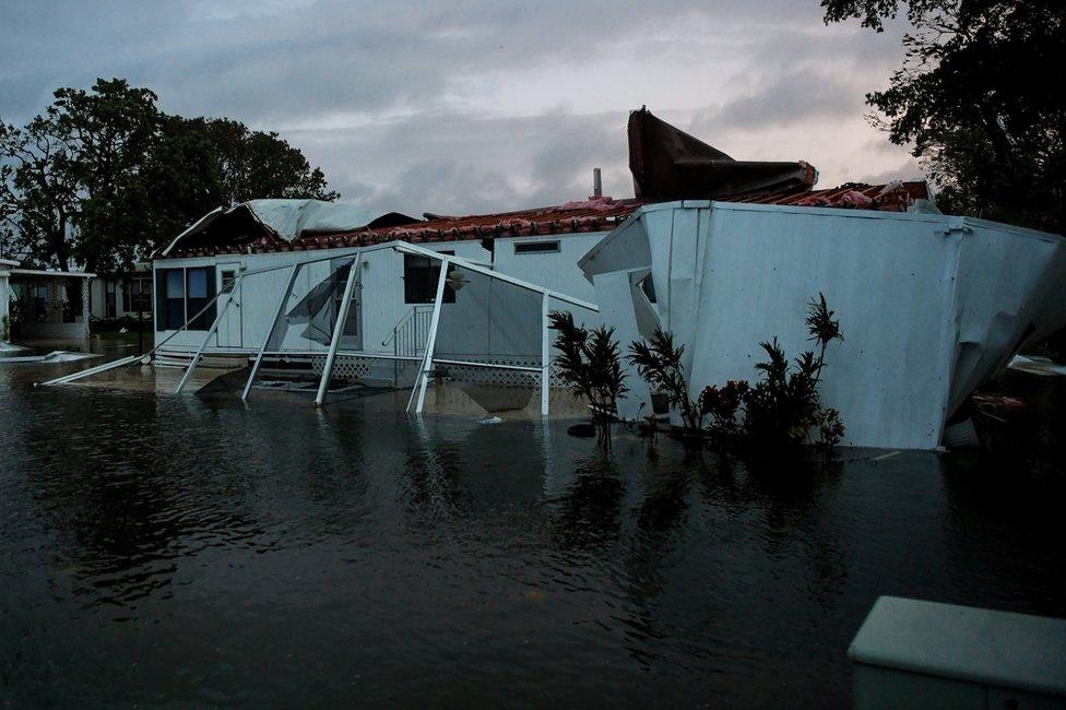 Flood water from Hurricane Irma surround a damaged mobile home in Bonita Springs, Florida, 10 September