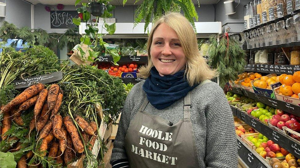 Leann Shaw at Hoole Food Market in Chester standing by a big pile of carrots