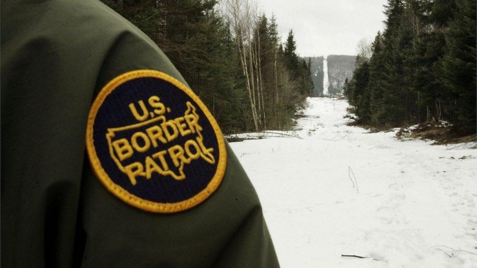 A US guard watches over the Canadian border near Beecher Falls, Vermont