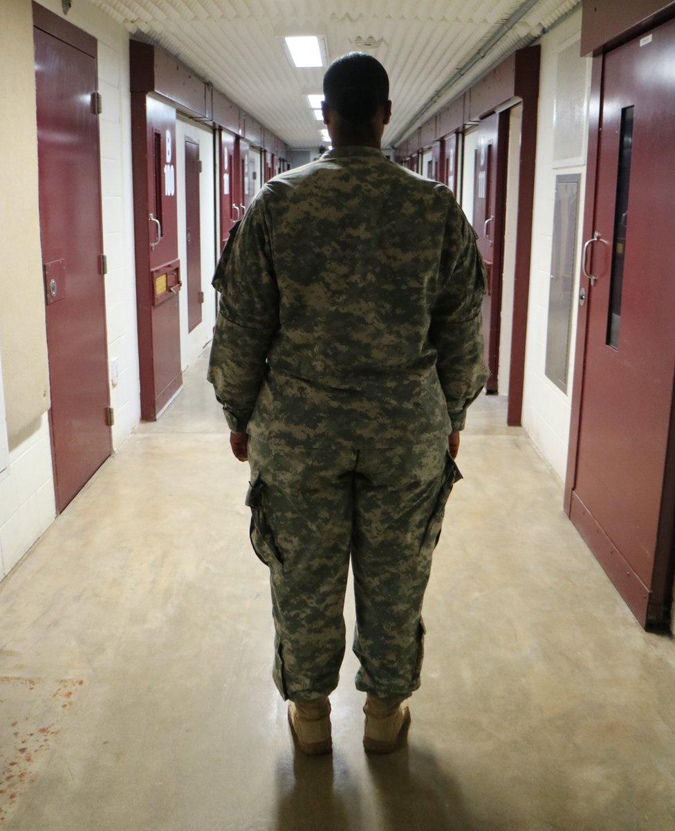 A soldier stands in a corridor, inside Guantanamo Bay