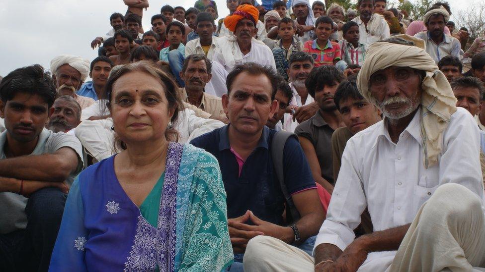 Amla Ruia sitting with a lot of local men