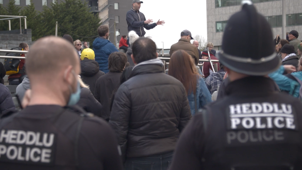 Protest yn erbyn y brechlyn tu allan i'r Senedd ym Mae Caerdydd