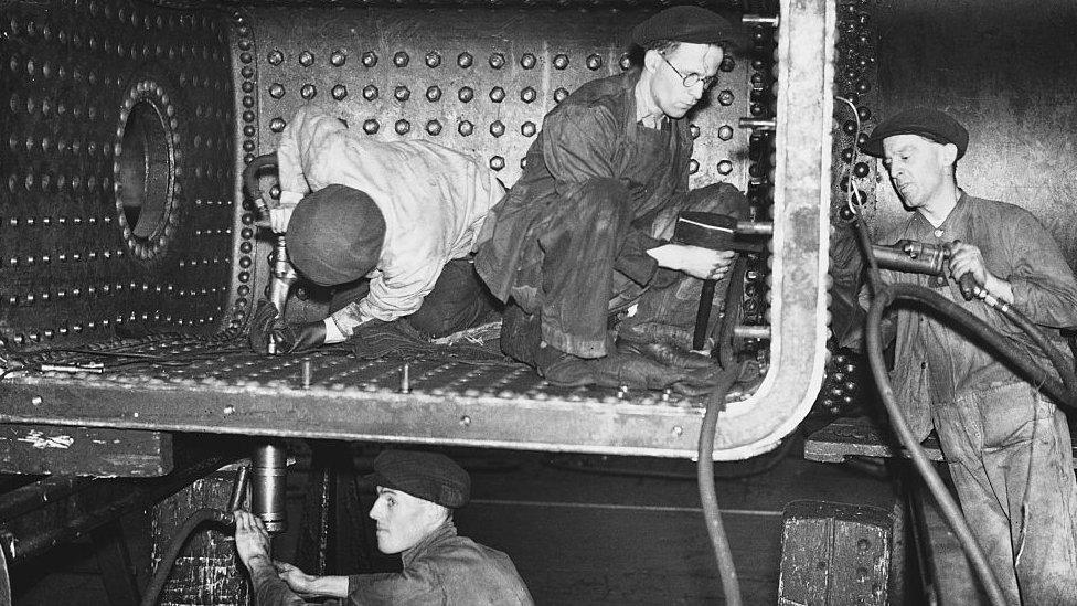 Crewe works. Rivetters at work on the throat plate and firebox sides of a locomotive boiler.