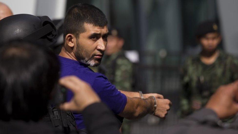 Police officers escort a key suspect in last month's Bangkok bombing, blue shirt, identified as Yusufu Mierali around a central Bangkok shopping centre during a reenactment for the 17 August bombing at Bangkok's popular Erawan Shrine Saturday, Sept. 26, 2015.