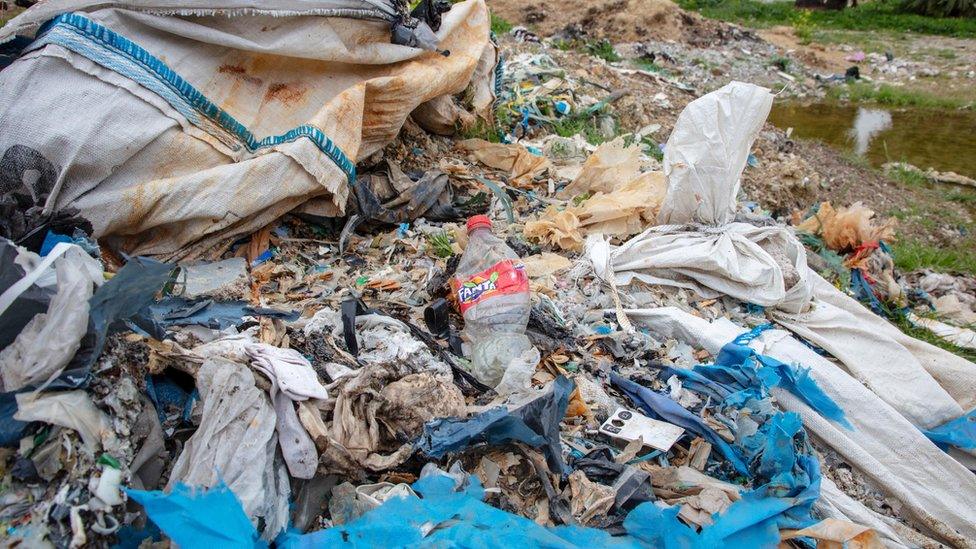 A Fanta plastic bottle is among the waste dumped and burned in Adana province in Turkey