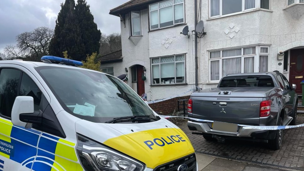 Police van outside the house where a woman and two boys were found dead