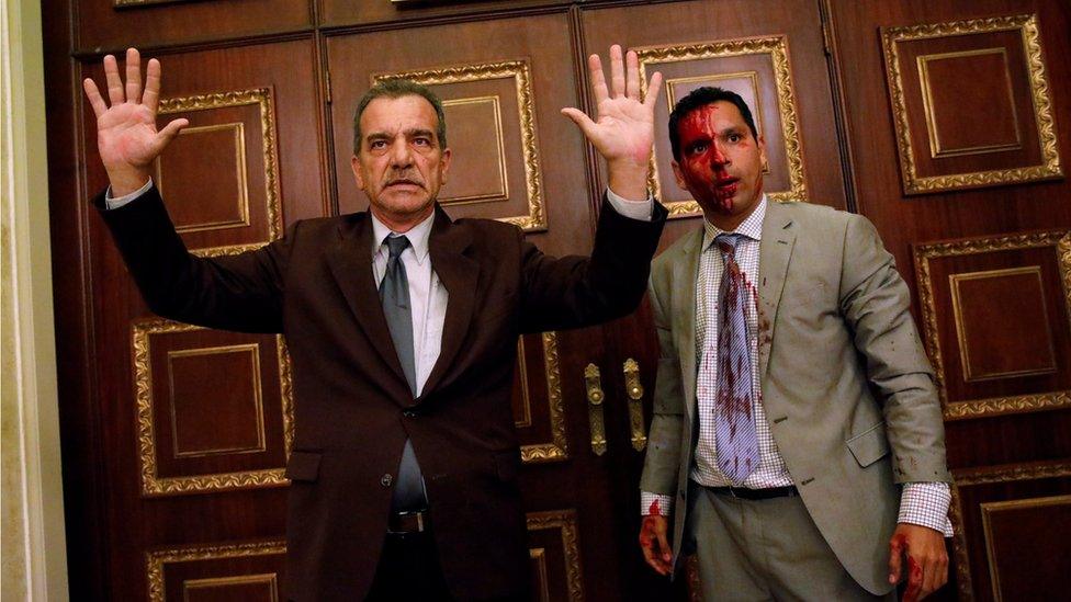 Opposition lawmaker Luis Stefanelli (L) gestures next to fellow opposition lawmaker Leonardo Regnault after a group of government supporters burst into Venezuela's opposition-controlled National Assembly during a session, in Caracas