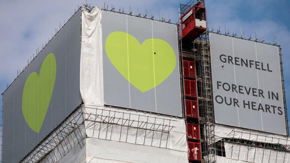 grenfell tower covered with banner reading Grenfell forever in our hearts