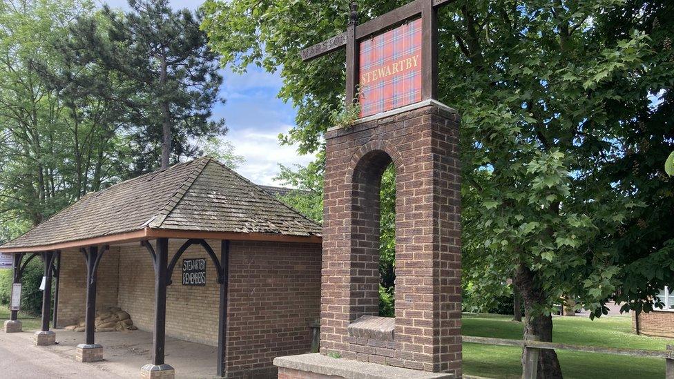 A Stewartby sign in Stewartby, Bedfordshire made out of bricks and a brick bus station