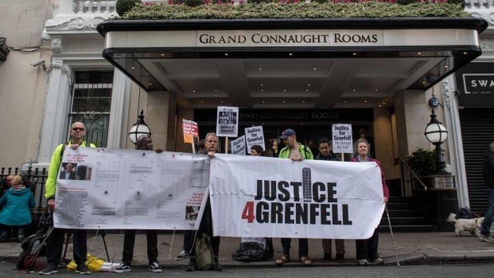 Demonstrators hold placards outside the venue of the inquiry into the Grenfell Tower fire