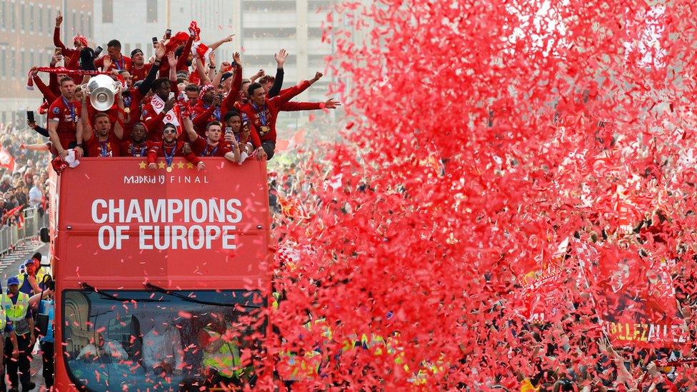 Liverpool's team bus travels past fans during the parade in 2019