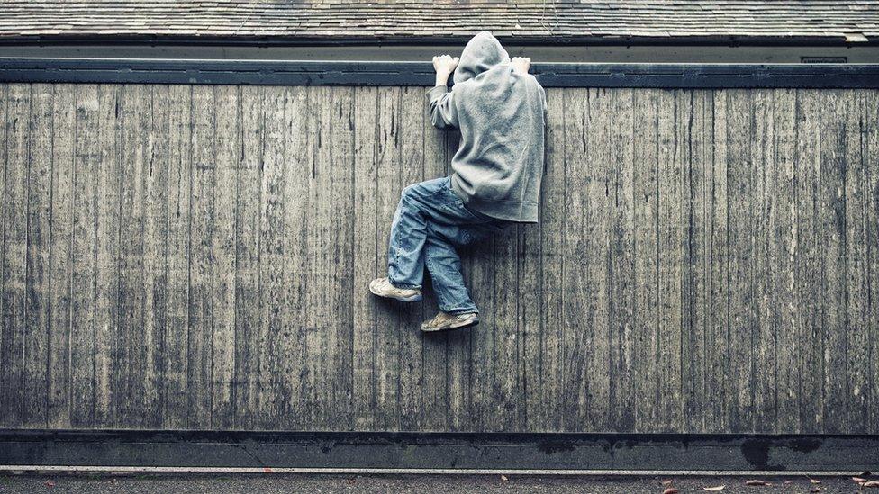 Child climbing fence