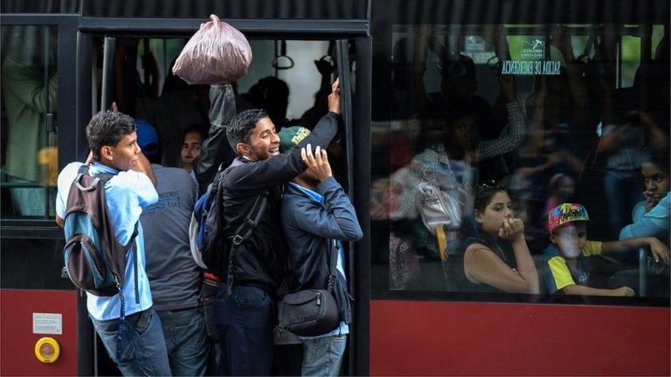 Locals use public transportation buses during a partial power cut in Caracas on February 6, 2018