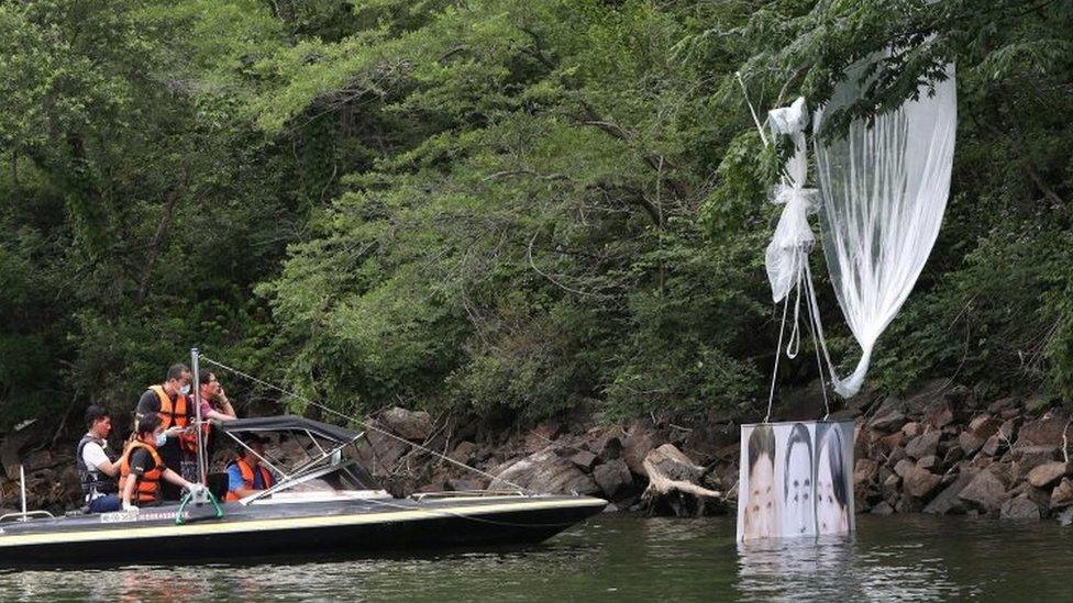 Police collect a balloon fallen in a river in South KOrea