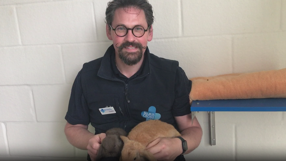 Charles White holding two rabbits