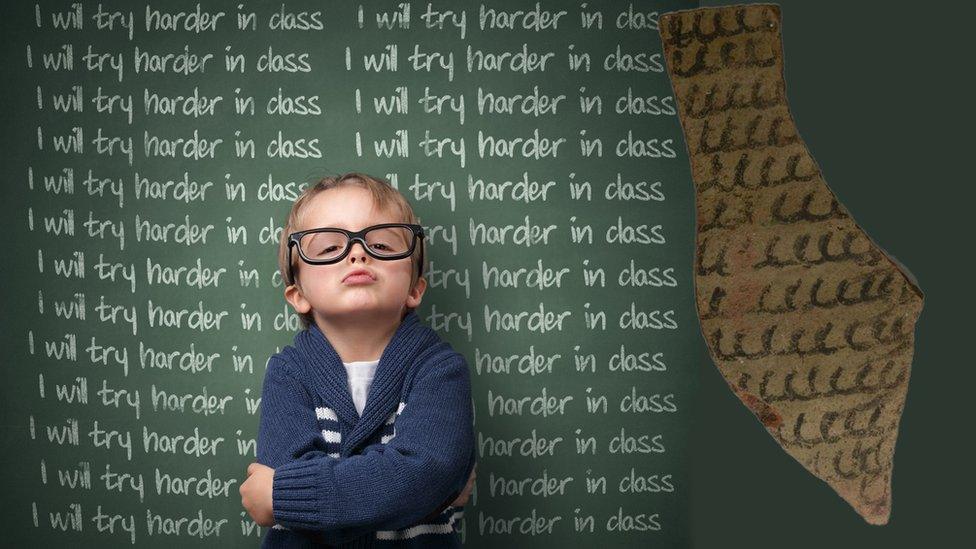 Boy in front of chalkboard with lines and a shard from the excavation at Athribis