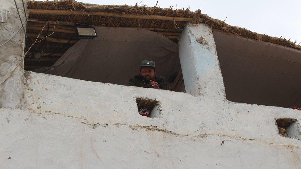 A guard looks out from a Kunduz prison watchroom