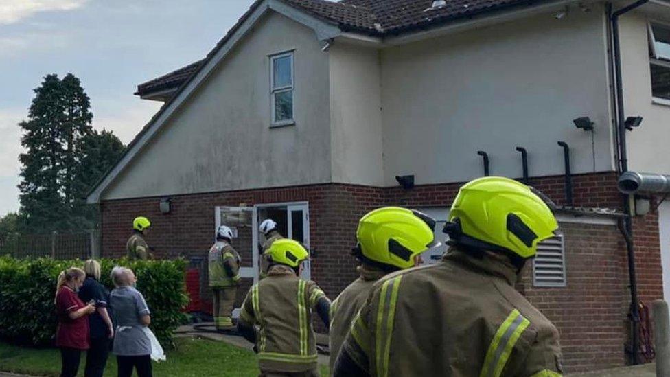 Firefighters and people standing outside a care home in Black Notley, Essex