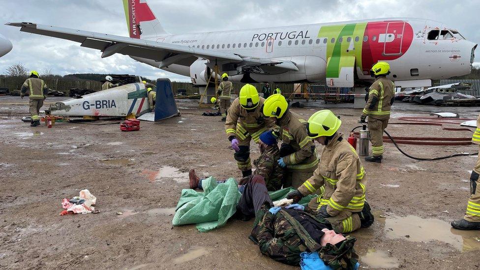 Firefighters treat an actor playing a casualty on the ground