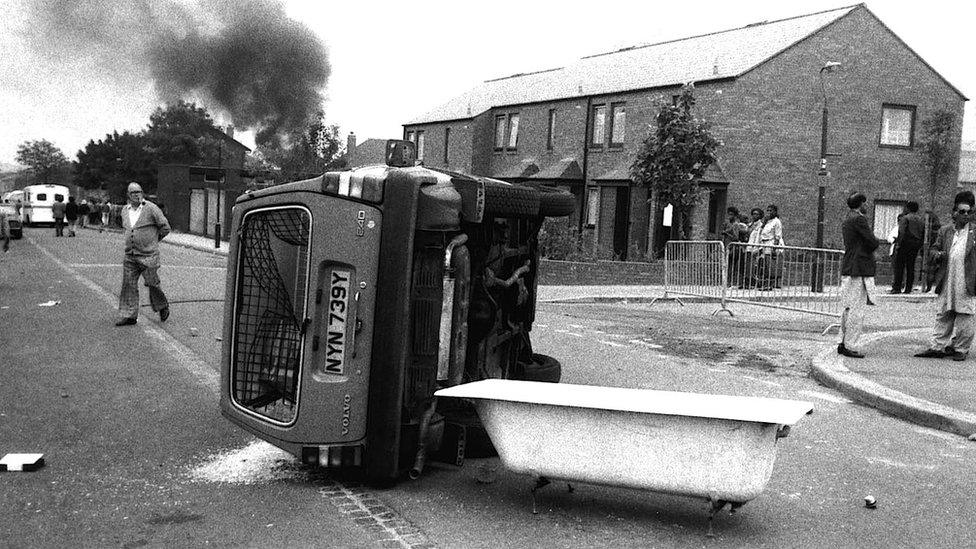 A car on its side during the riots