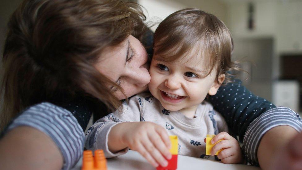 Mother kissing toddler