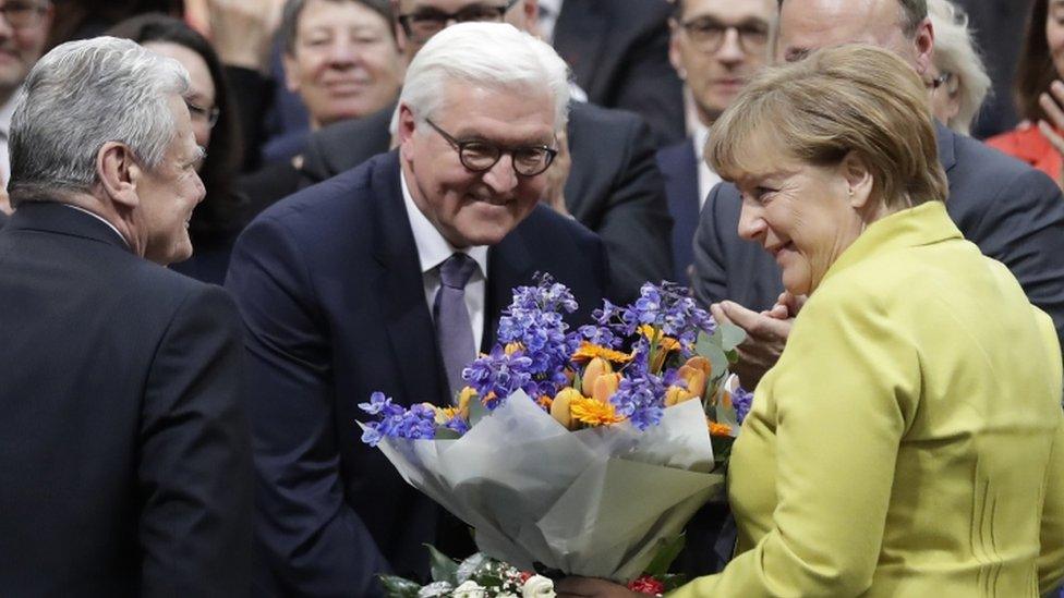 Newly elected German President Frank-Walter Steinmeier, centre, is congratulated by German President Joachim Gauck, left, and German Chancellor Angela Merkel, right.