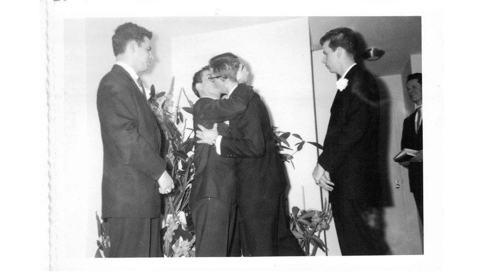 Two grooms kiss at their wedding