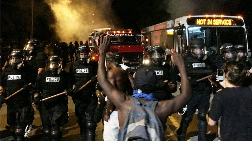 Police officers wearing riot gear block a road during protests after police fatally shot Keith Lamont Scott in the parking lot of an apartment complex in Charlotte, North Carolina, US 20 September 2016