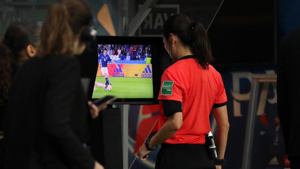 A referee looking at the VAR monitor.