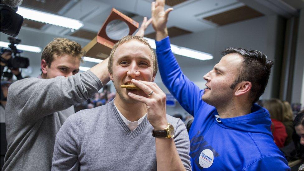 A previous supporter of Democratic presidential candidate Martin O'Malley eats a cookie as he is persuaded to support Democratic presidential candidate Sen. Bernie Sanders during caucus night at the State Historical Society of Iowa, on Monday, Feb. 1, 2016 in Des Moines, Iowa.