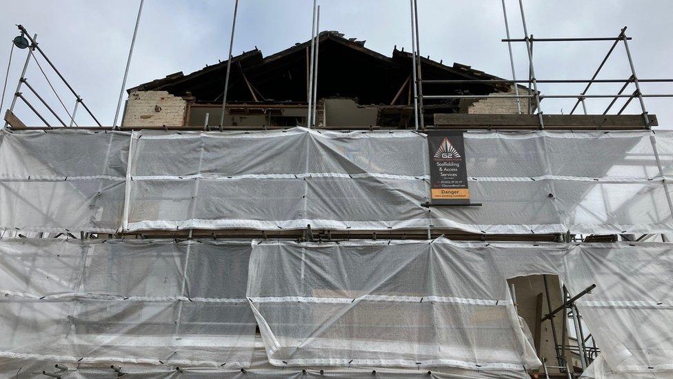 Tarpaulin covering a house and mural