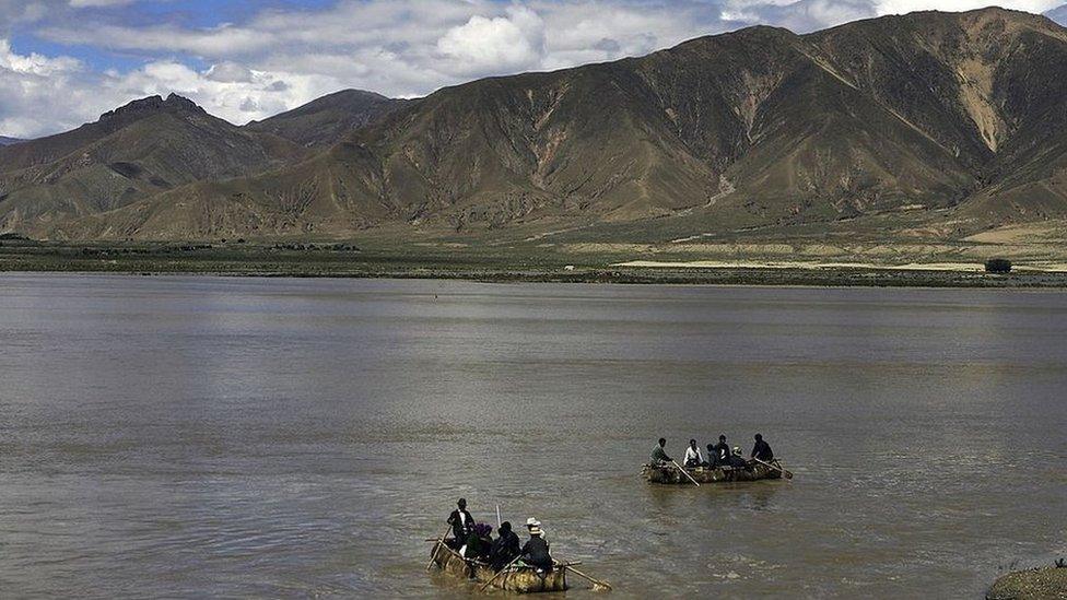 Tibetan people row cowskin rafts on the Brahmaputra River on August 30, 2006 in Renbu County of Tibet Autonomous Region, China. Cowskin is a traditional material used to make rafts for fishing and to cross rivers and lakes for the Tibetan peole.