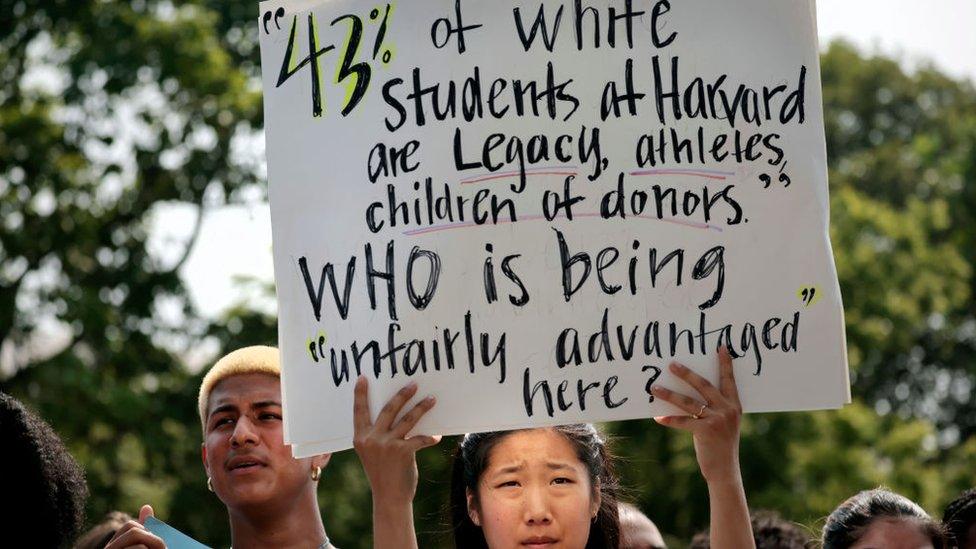 A Harvard student holds a sign during a rally protesting the Supreme Court's ruling against affirmative action