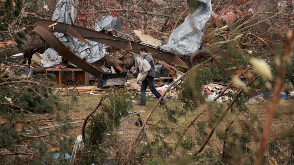 A resident sorts through rubble