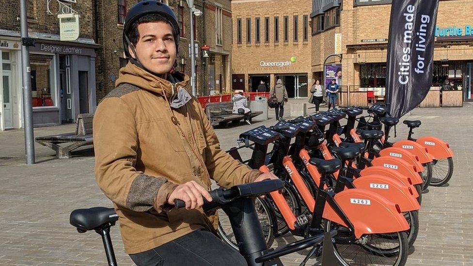 A person sitting on an e-bike in the middle of Cathedral Square in Peterborough