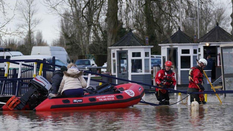 Person in raincoat being rescued on a red inflatable