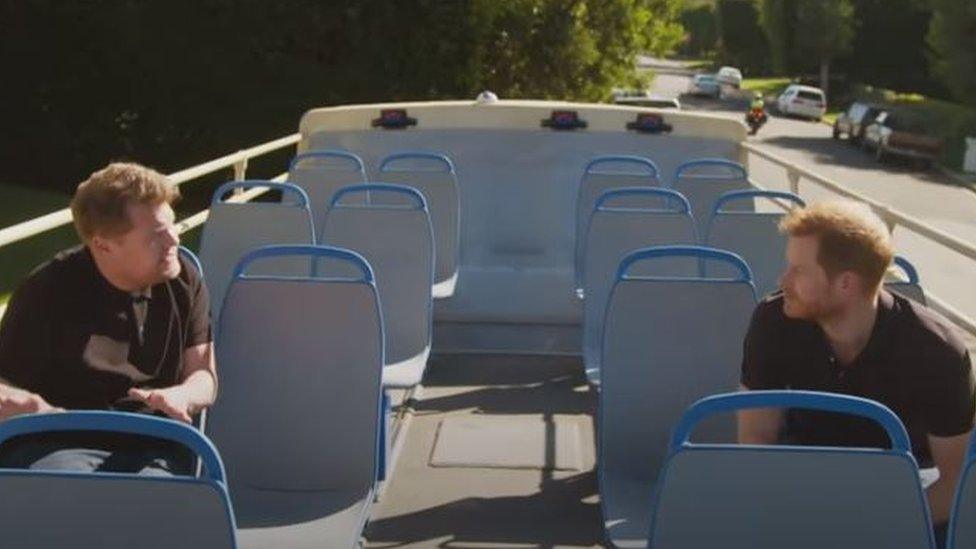 British chat show host James Corden (left) pictured on a double-decker bus with Prince Harry (right)