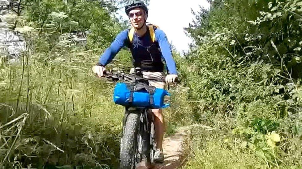 Jon Cuthill rides mountain bike down overgrown path