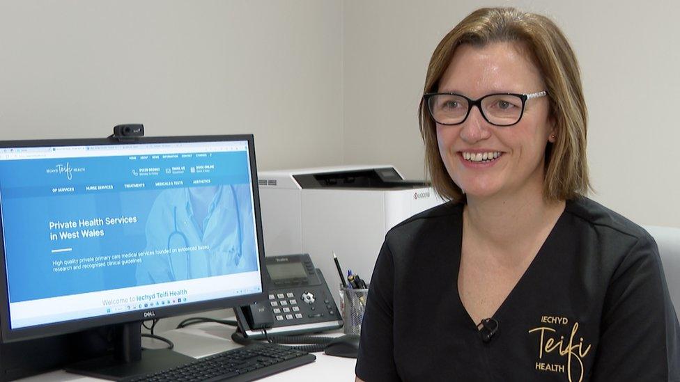 Dr Beth Howells smiling while sitting in front of a computer