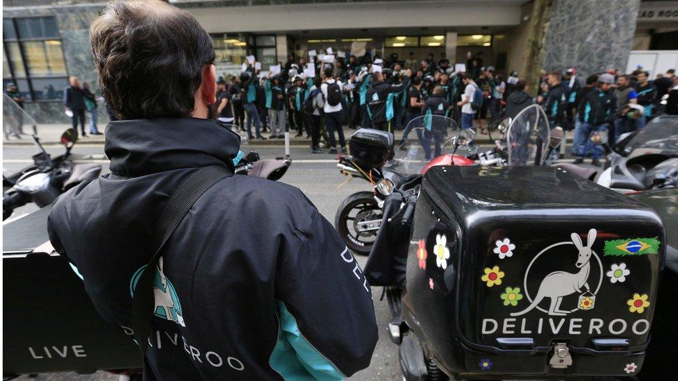 Deliveroo riders holding a protest over pay outside the company HQ in London, as the food delivery company has been told by the Government that it must pay its workers the minimum wage unless it reaches agreement in the courts to treat them as self-employed.