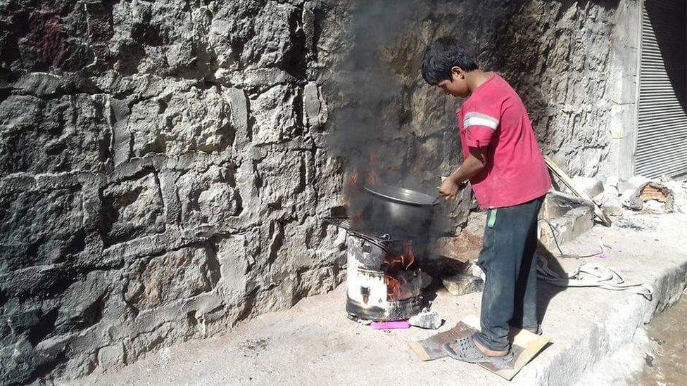 Picture of a child cooking on a makeshift stove