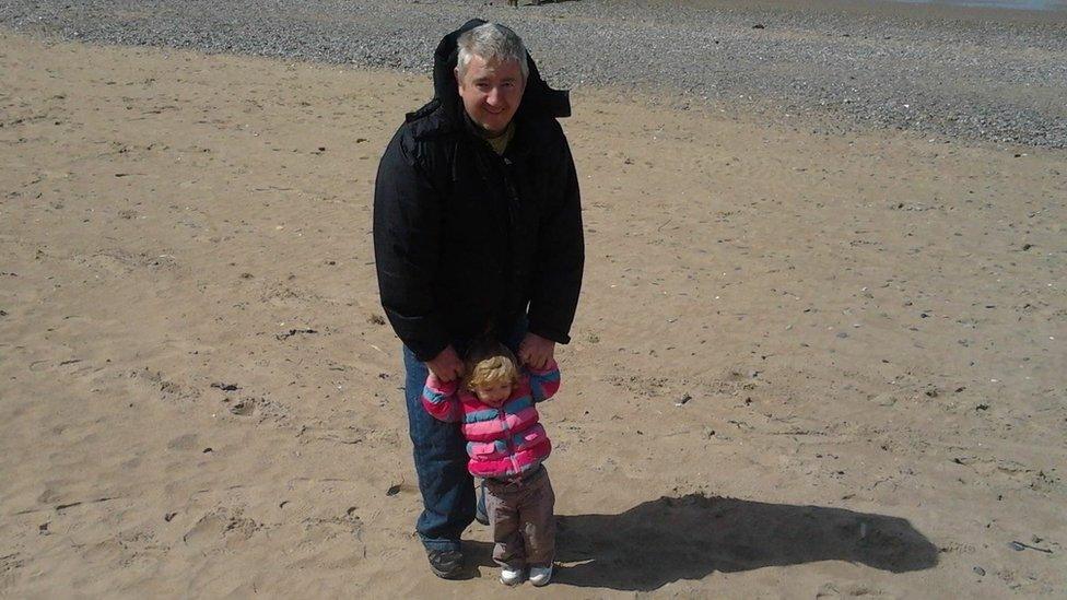 Steven on the beach with his daughter.