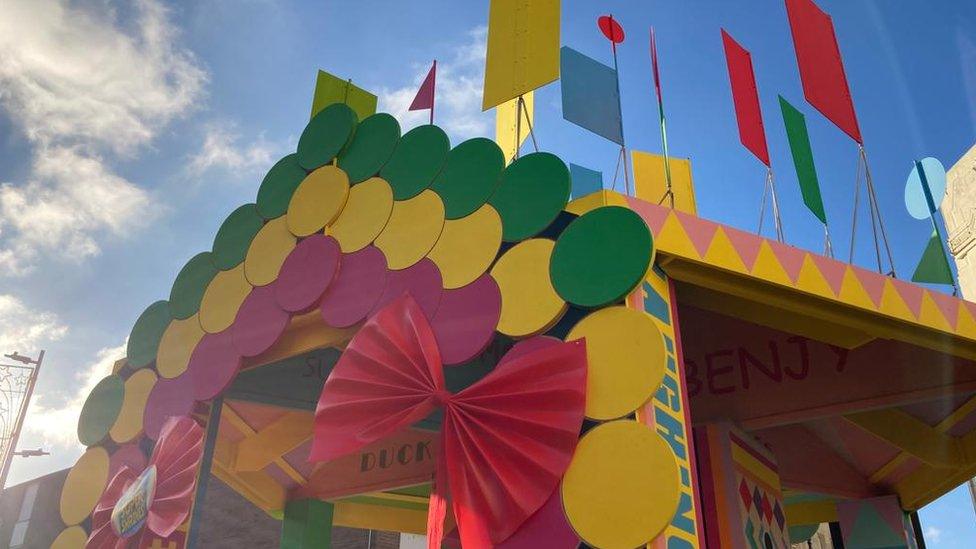 The top of the bandstand with flags, colourful circles and ribbons