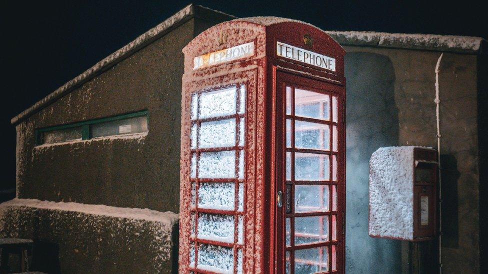 iconic red telehphone box covered in snow in aberdeenshire